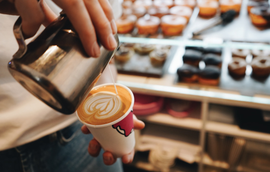 pouring coffee cream design with doughnuts in the case